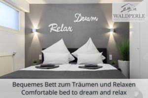 a bedroom with a bed with white sheets and pillows at Exklusives 5-Sterne Apartment Waldperle mit Indoor-Pool, Sauna, top Lage und Ausblick in die Natur, Hunde willkommen in Schonach