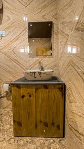 un bagno con lavandino e specchio di Basho Mud Huts a Bashist
