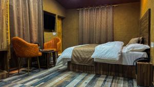 Een bed of bedden in een kamer bij Basho Mud Huts