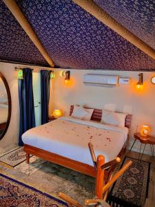 a bedroom with a large bed and a purple ceiling at Shivgarh Sustainable Resort in Dādu