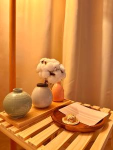 a table with two vases and a flower in a vase at KSPO,JYP,LotteTower, Sodamjae Stay in Seoul