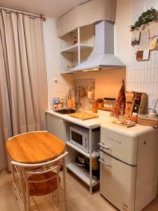 a small kitchen with a table and a stove at KSPO,JYP,LotteTower, Sodamjae Stay in Seoul +10 photos