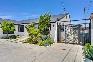 a white house with a gate and plants at Luxury 2 bedroom villa in Huntington Beach