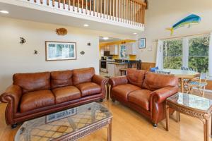 a living room with two leather couches and a table at 6134 - Peace of Mine in Nags Head