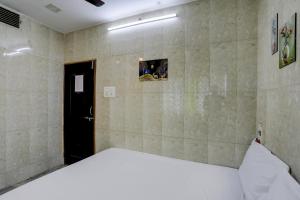 a bedroom with a white bed in a room at Hotel O DREAMZZ INN in Nagpur