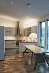 a kitchen with a wooden table in the middle at Arctic Fox Rovaniemi in Rovaniemi