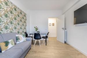 ein Wohnzimmer mit Sofa und Tisch in der Unterkunft Green House Marconi in Rom