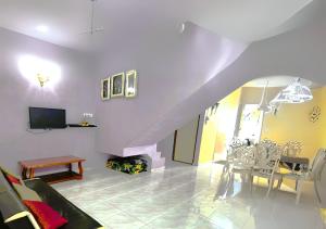 a living room with a staircase and a table and chairs at NO DEPOSIT - BIG Home 2-sty Terrace Near World Theme Park Hot Springs & Night Park max 6person in Ipoh