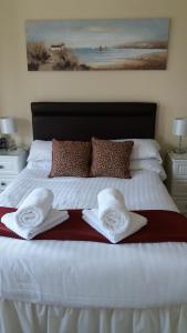 A bed or beds in a room at Hafan-y-Mor Guesthouse 