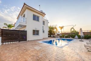 a villa with a swimming pool in front of a house at Villa Oceania in Ayia Napa