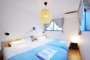 a bedroom with two beds and a chandelier at Manere in Tokyo