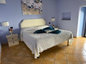 a bedroom with a bed with a blue wall at Luna Convento Copanello B&B in Stalettì