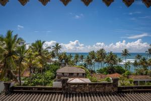 a view of a building with palm trees and the ocean at Lavender mirissa in Mirissa