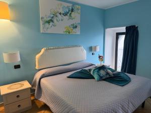a bedroom with a bed with a blue wall at Luna Convento Copanello B&B in Stalettì