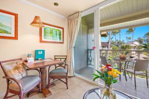 a room with a table and chairs and a balcony at Islander on the Beach 343 in Kapaa