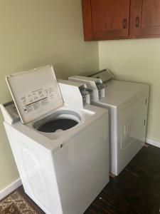 a washer and dryer in a corner of a room at Kona Wave Rider - Island Sanctuary with Ocean Soul in Kailua-Kona