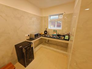a small kitchen with a sink and a microwave at DREAM STAYS - NEAR AlRPORT in Chennai