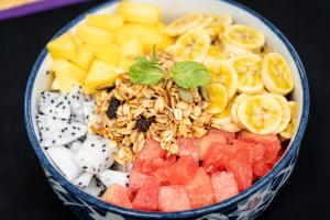 een schaal gevuld met groenten en fruit op een tafel bij Ground Zero Martial Arts and Yoga in Phumĭ Réach Born