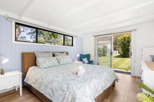 a bedroom with a bed with a teddy bear on it at A Touch Of Paradise - 4 MIn Walk to Beach in Callala Beach