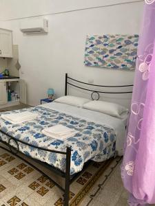 a bedroom with a bed with a blue and white comforter at Ponzamania Da Cecilia in Ponza