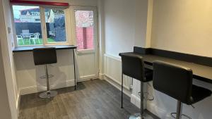 a barber shop with two chairs and a table and a window at Kingsholm House on the Rainbow Street-4 Bedroom-Sleeps 8 in Gloucester