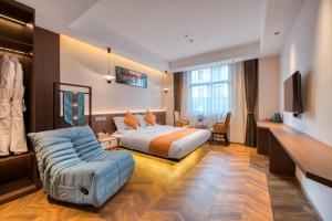 una camera d'albergo con un letto e un divano di 南浔浔溪之畔民宿 a Huzhou