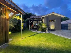 a backyard with a shed and a grass yard at Villa Mäenma in Le Teich