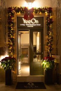 een ingang van een winkel versierd met kerstverlichting en bloemen bij YeeOn Boutique Hotel, Gythio - Historic Hotels of Europe in Gythio