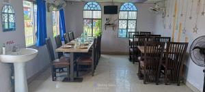 Un comedor con mesa y sillas y un fregadero. en Star inn resort, en Tajpur