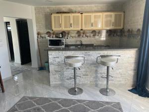a kitchen with a counter and bar stools in it at Royal Chalet Maamourah Beach in Alexandria