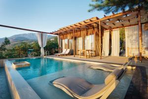 a swimming pool with chairs and a house at Lov Faralya Adults Only in Faralya