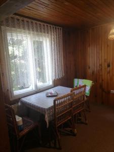 ein Esszimmer mit Tisch und Stühlen und einem Fenster in der Unterkunft Zabljak Dela Ma in Žabljak