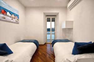 a living room with two beds and a painting on the wall at la vista sul lago in Castel Gandolfo