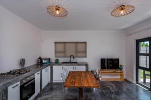 a kitchen with a table and a stove top oven at S Haven Luxury Self Catering Apartment in Franskraalstrand
