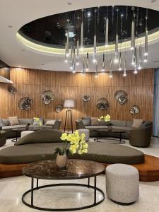a living room with couches and a chandelier at Tropical Sanctuary in Pasay City in Manila