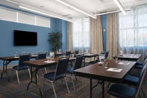 a conference room with tables and chairs and a flat screen tv at Four Points by Sheraton Fort Lauderdale Airport/Cruise Port in Fort Lauderdale
