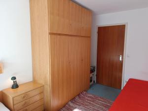 a bedroom with a wooden closet and a bed at 2-Raum FeWo Lichtnelke - Hallenbad & Sauna in Fischen +4 photos