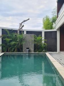 a pool with a fountain in the middle of a house at DKD ROOM Pererenan Canggu in Canggu
