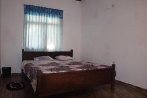 a bedroom with a wooden bed with a window at VIHANSHA Guesthouse in Weligama