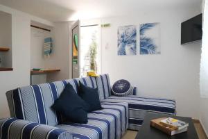 een woonkamer met een blauwe en witte streepbank bij Blue Marina in Sivota