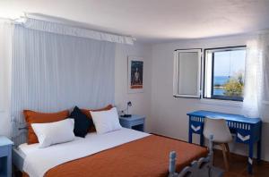 een slaapkamer met een bed, een blauw bureau en een raam bij Blue Marina in Sivota
