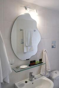 een witte badkamer met een wastafel en een spiegel bij Blue Marina in Sivota +8 foto's