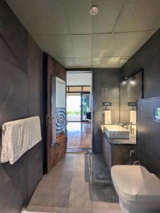 a bathroom with a sink and a toilet and a mirror at Ira Kabini by Luxunlock Private Villas in Antarasante