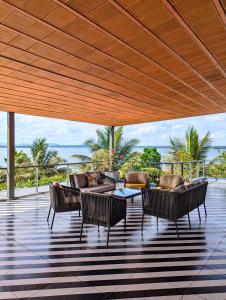 a patio with chairs and couches and a table at Ira Kabini by Luxunlock Private Villas in Antarasante