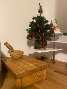 a christmas tree on a table next to a table with a wooden coffee table at House of Zimon in Aldeno