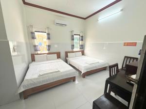 a room with two beds and a piano in it at Nhà nghỉ Phát Thảo in Hà Tiên +15 photos