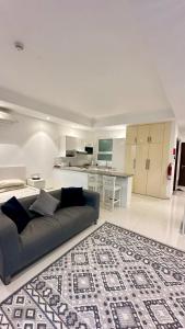 un salon avec un canapé et une cuisine dans l'établissement 1 Hawana VIP Studio, à Salalah