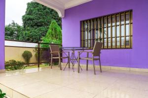 洛美Sublime modern villa的紫色客房的阳台配有桌椅