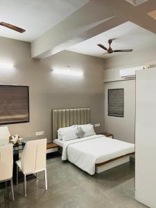 a bedroom with a bed and a table and chairs at Pvr House Ahmedabad in Ahmedabad