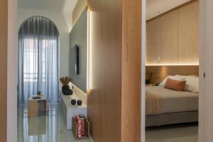 a bedroom with a bed and a wall with a mirror at Amara Local Experience in Chania Town